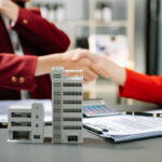 Real estate agent and client shaking hands over a property investment agreement