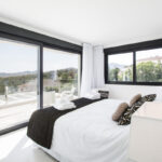 Modern luxury bedroom with large windows and balcony view in Dubai apartment